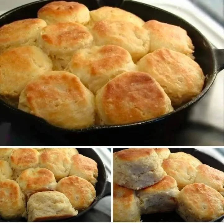 Freshly baked biscuits on a rustic wooden table with butter and jam