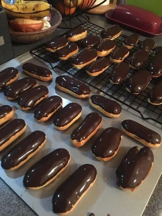 Homemade chocolate eclairs with rich chocolate glaze on a plate