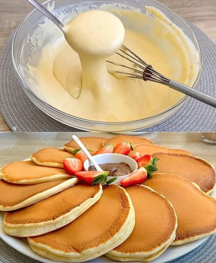Fluffy pancakes stacked on a plate with syrup and berries